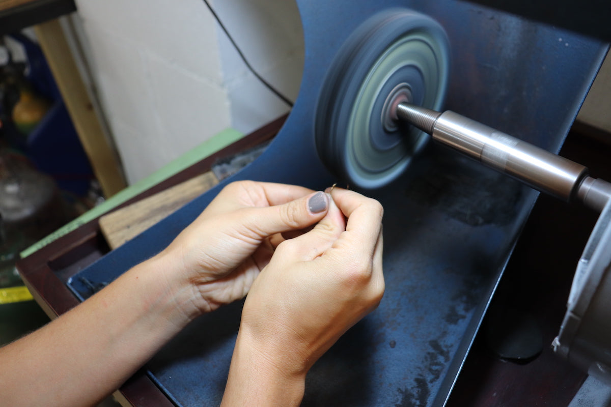 Student using polishing machine during a ring making workshop at Fitzgerald Jewelry