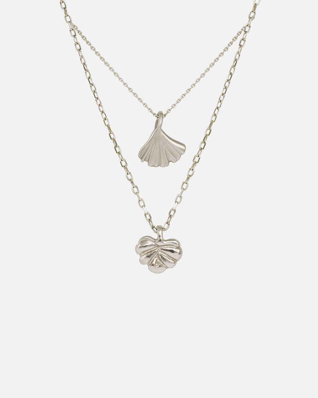 Front view of Ginkgo Necklace in 14k white gold and Lotus Necklace in 14k white gold hanging together